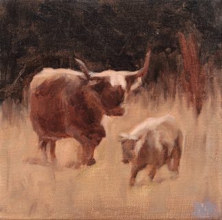 A cow and its calf walk together through a field